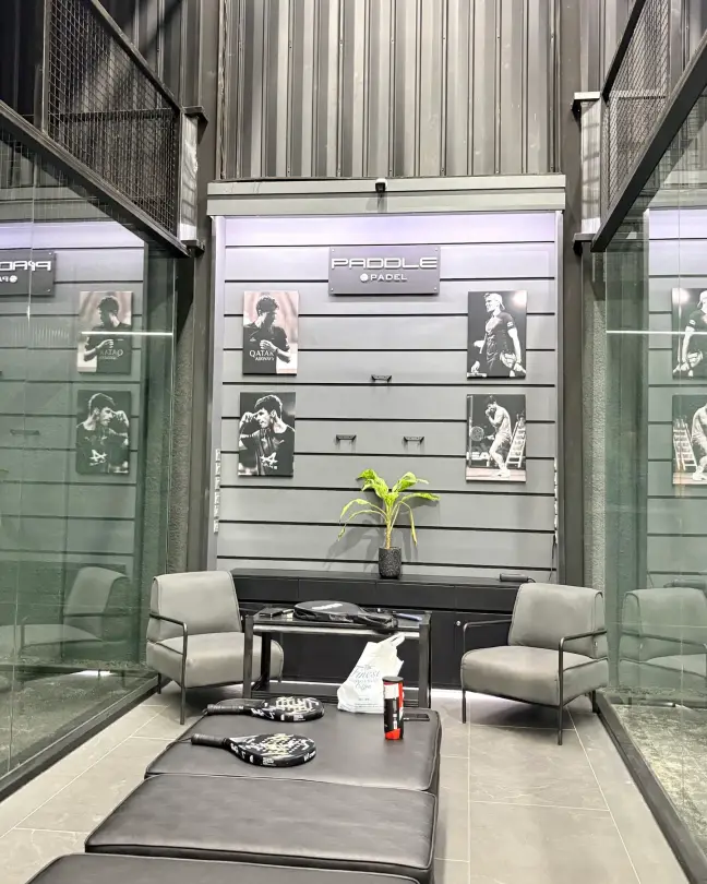 Lounge with armchairs and framed padel photography
